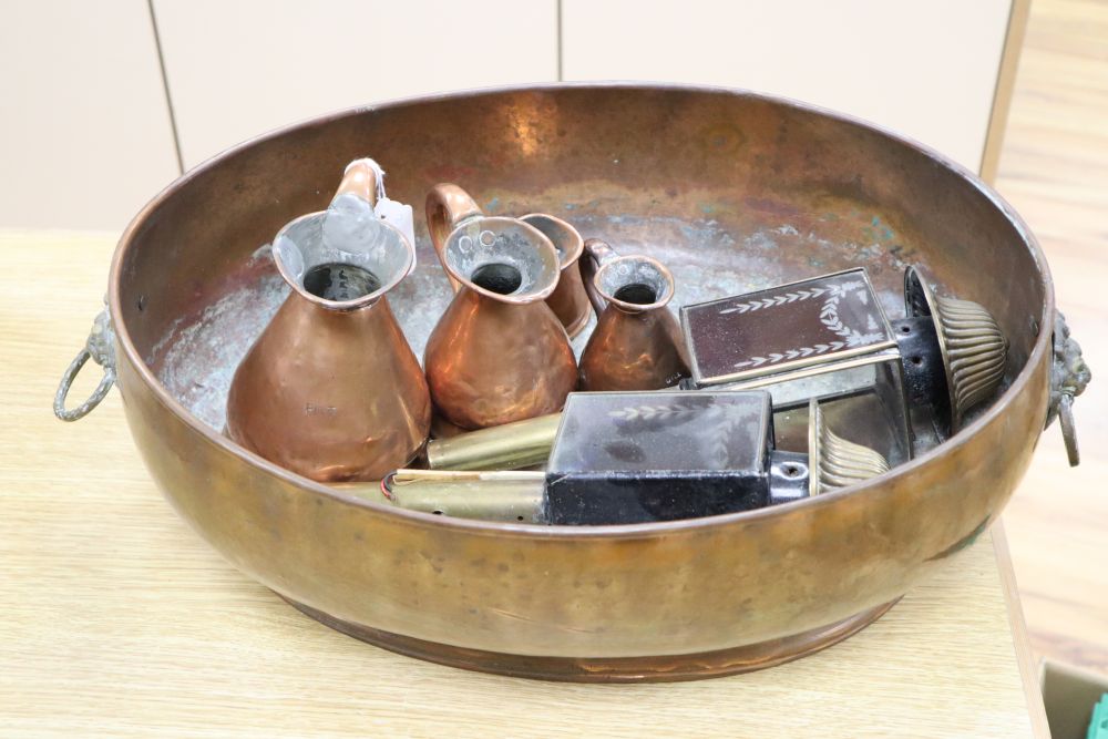Four copper graduated jugs and a pair of red glass and brass coaching lamps and a copper two-handled planter